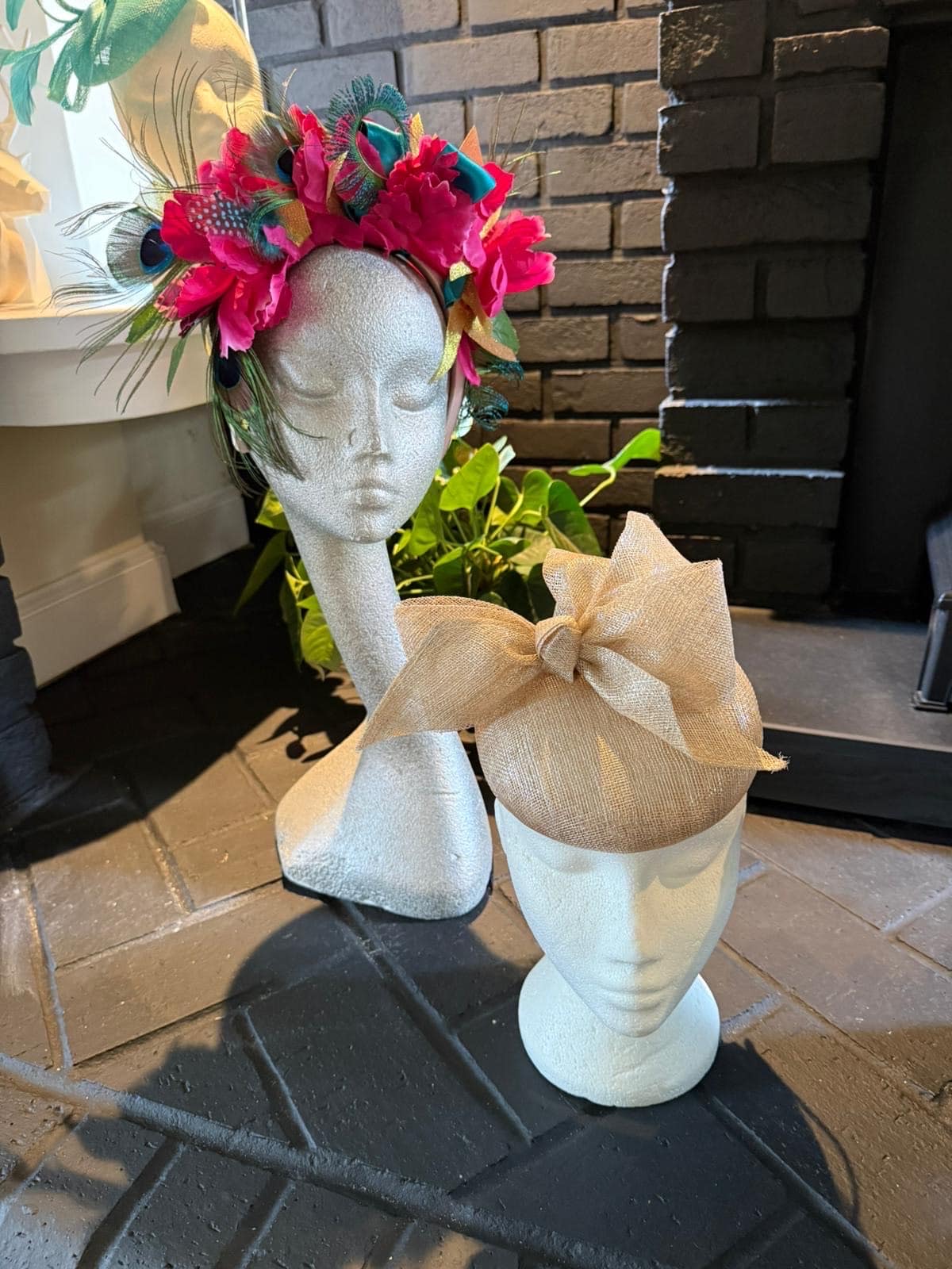 Pink flower crown with peacock feathers and a gold bow pillbox headpiece